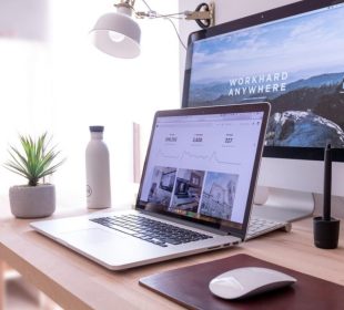 A laptop computer sitting on top of a wooden table